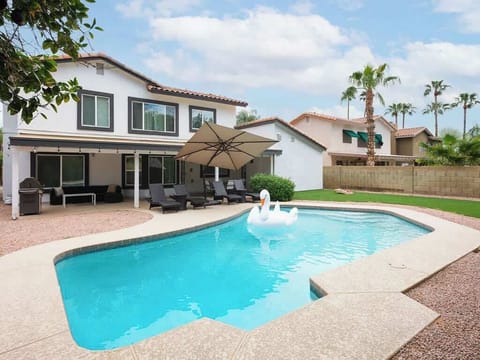 Spacious backyard with a private pool, sun loungers, BBQ, covered patio, outdoor dining, seating area, and corn hole!