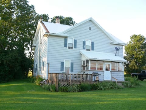 Outside back of the house with deck; opening from enclosed back porch to kitchen