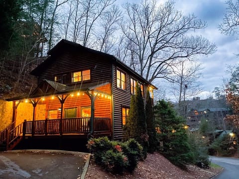 Smoky Mountain Escape — the whole cabin lit up warm out front after dark