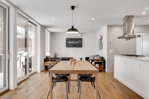 Gather around your spacious dining table while meals simmer on the sleek stovetop, sunlight streaming through floor-to-ceiling windows into this modern retreat.
