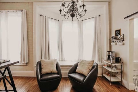 East Suite living room with large bay window and two leather barrel chairs – peaceful Clare Michigan vacation rental nook perfect for quiet morning coffee