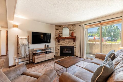 Cozy living room with fireplace, open layout, and sliding doors to the patio—ideal for unwinding after your adventures.