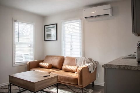 Warm living room with a tan sectional, natural light, and cozy atmosphere.