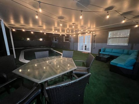 Partially covered backyard with comfortable patio lounge furniture and a pool for spending time with family