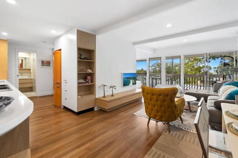 Open-plan living includes a 65-inch Smart TV and sliding doors to balcony views.