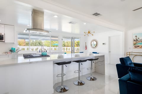 Enjoy breakfast at the sleek, modern breakfast bar, where the natural light streaming through the windows highlights the beauty of the spacious kitchen.
