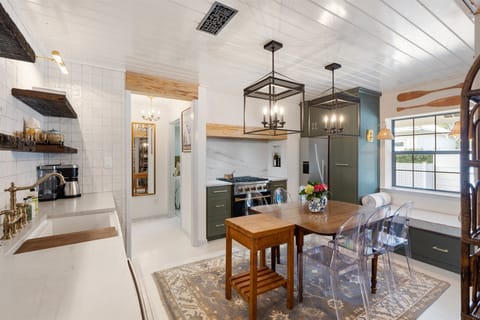 Eat-in kitchen with gas range and custom hood.