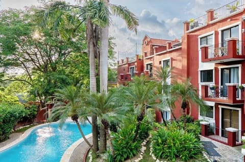 Tropical oasis with resort pool, private balconies & lush gardens.