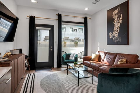 Cozy living room with 70 Smart TV, comfortable leather couch that turns into a Queen sized pullout couch, Record player with vinyls albums and an open concept kitchen. Private patio off of living room.