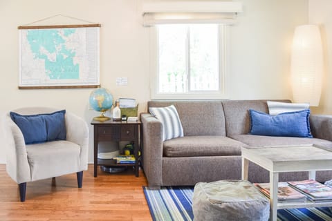 Living room with pull out full size sofa bed, reading materials, games, & toys.