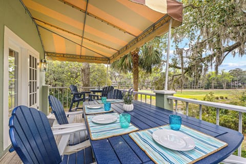 This covered patio offers a quiet, private setting with peaceful views of Shipyard's lush green space, lagoon,  and mature trees.