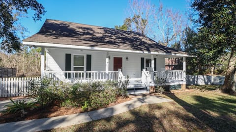 Front view of home nestled between gorgeous oaks trees & 1 block to the beach