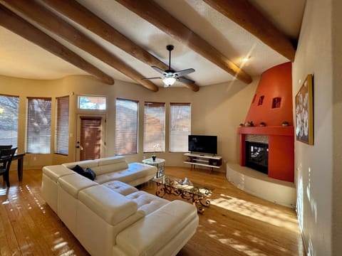 Living room area with vaulted ceilings, gas fireplace and beautiful wood beams.