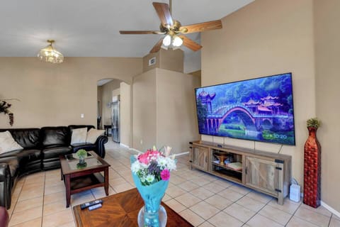 Hero shot - Bright living room with big smart TV, leather sectional & vaulted ceilings