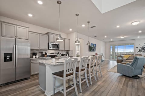 Modern Style Downstairs Area with Kitchen, Barstool Seating, and Living Room Lounge