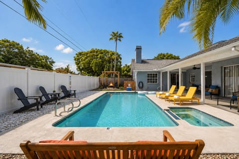 From the bench looking across the pool with the spa, loungers, and fire pit
