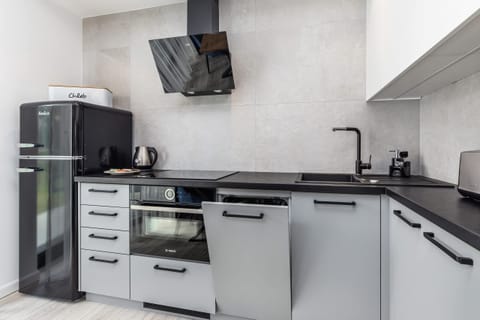 Kitchen area with a modern electric stove and black countertop, minimalistic and functional.