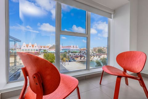 Sink into modern comfort while savoring views of vibrant architecture and tropical palms—your personal window to paradise awaits.