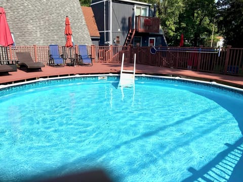 24' diameter outdoor above-ground summer pool with deck and chaise lounge chairs