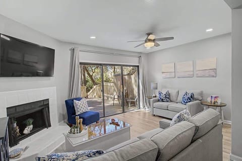 Sink into plush sofas in your elegantly furnished living room, where the fireplace adds warmth and patio doors invite natural light.