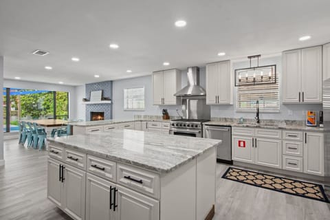 An open kitchen with sleek stainless steel appliances, illuminated by warm, stylish lighting that adds a touch of charm.