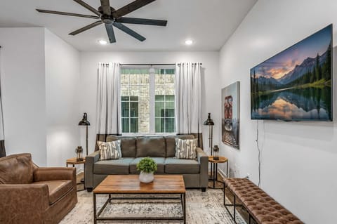 Open, airy living area with comfy seating and a wall-mounted Smart TV.