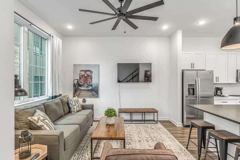 Modern living room with bright ambiance, comfy seats, and a Smart TV.