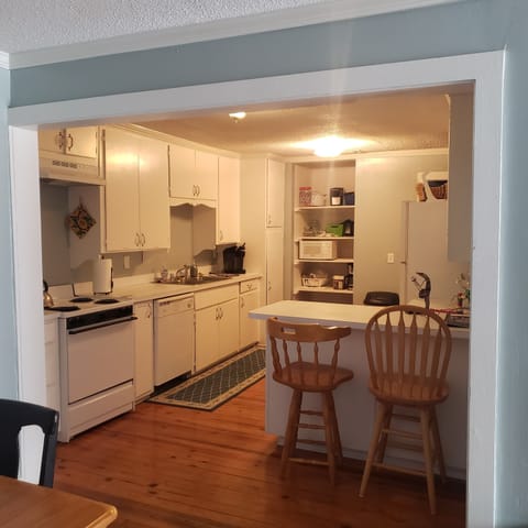 View into kitchen with additional kitchen seating 1 / 2
