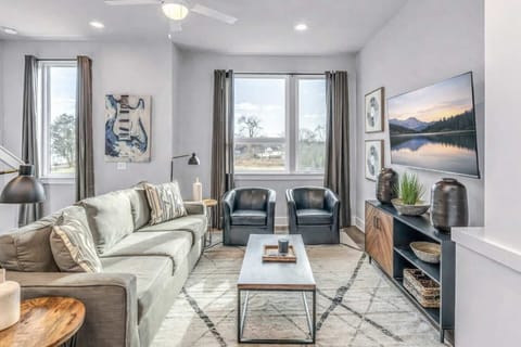 Relax in a sun-filled living room with comfortable seating and Smart TV.