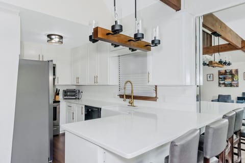 Remodeled kitchen with quartz countertops and new appliances.