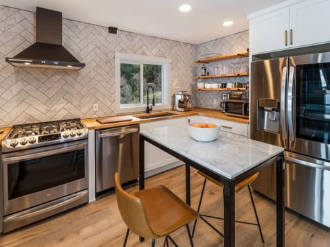 Gourmet kitchen for the chef-at-heart
You'll find the kitchen is well stocked with spices and quality cookware for guests to prepare meals during their stay.
An island with seating and stainless-steel appliances makes this kitchen a cook's dream.