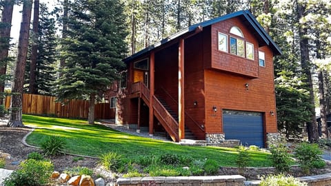 Charming mountain cabin nestled among towering pines with garage parking and beautifully landscaped grounds.