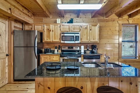 Kitchen with granite countertops and island with two adjustable stools