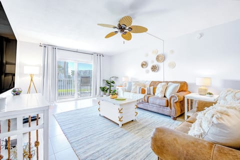 Bright and airy living space with cozy seating and a stylish ceiling fan