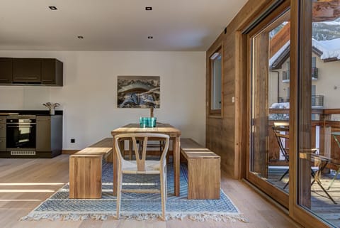 Large dining table in front of glass doors onto balcony 