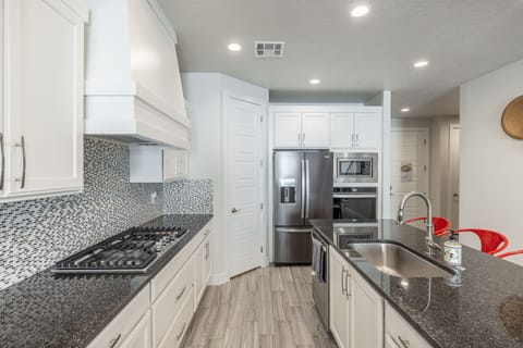Kitchen side view - Side view of kitchen showing off the beautiful counter tops and stainless-steel appliances.