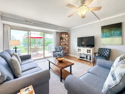 Bright living room with comfortable seating and a view of the outdoor patio.