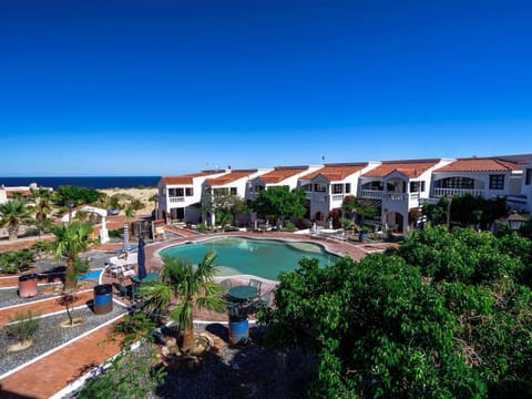 A breathtaking wide-angle drone shot capturing the main building and pool area of this stunning coastal property.