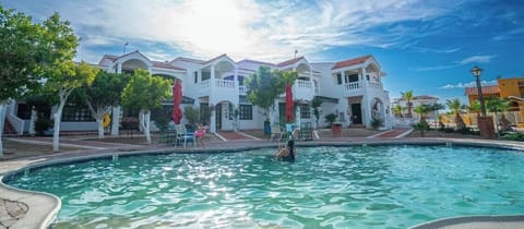 This two-story condominium building sits on landscaped grounds with a community swimming pool at its center — pool access is typically available during summer months