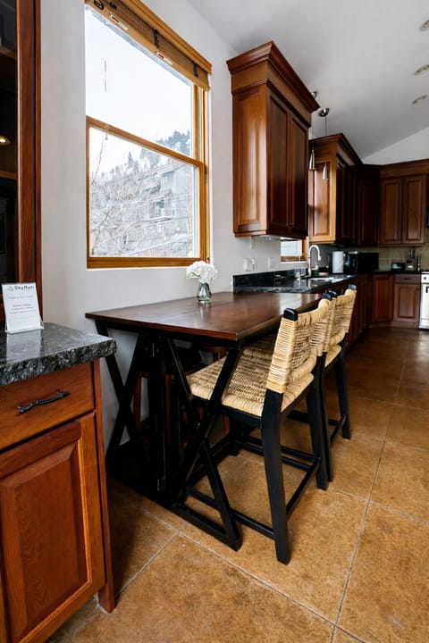 Gather around the breakfast bar where rich wood cabinets meet modern convenience—your morning coffee tastes even better with snowy mountain views. Unit A