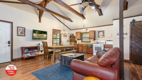 One large room with a full kitchen, large dining table, couch, and beds.