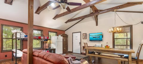 One large room with a full kitchen, large dining table, couch, and beds.