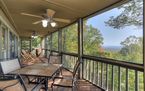 Enjoy meals and relaxation on the scenic screened-in porch with stunning views.