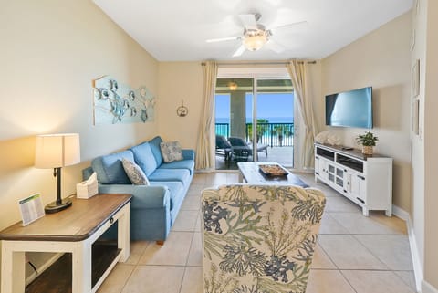 Unwind in your coastal haven with plush blue sofas and entertainment center, while your private balcony beckons with ocean breezes.