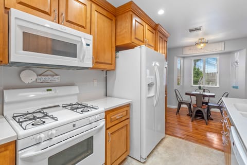 Kitchen with chef grade appliances. The kitchen is stocked with cookware, dinnerware and glasses.