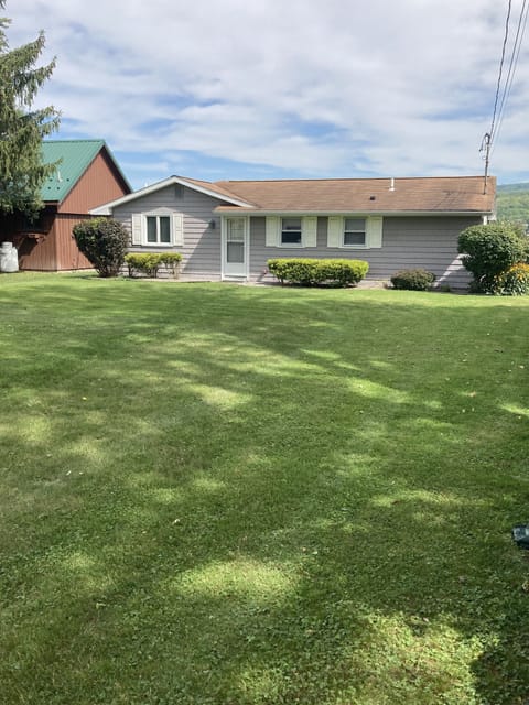 Great view of the cottage front with large lawn 
