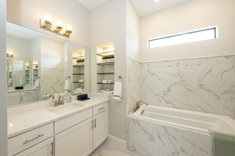 Master bathroom (view 1) with a tub and shower