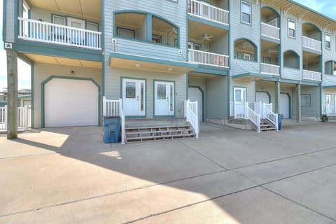 Coastal property entrance featuring multi-level accommodations with private balconies and convenient ground-level parking access.