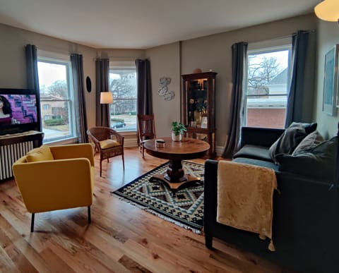 The oak floors of this historic home give the living room a cozy, yet elegant feel. The room holding a 55 Inch TV (Roku and Netflix), Gig Speed Internet and Mini Pool Table overlooks Oak Park Avenue .