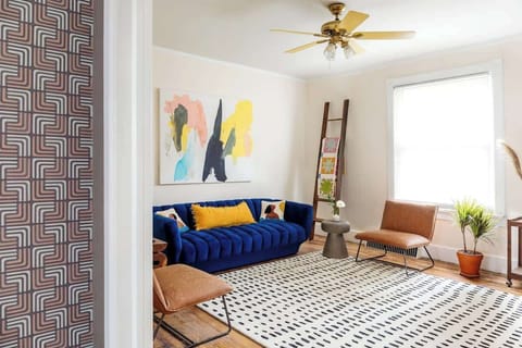 Cozy living room with a large blue velvet couch. Bright and fun. Perfect for lounging or hosting.